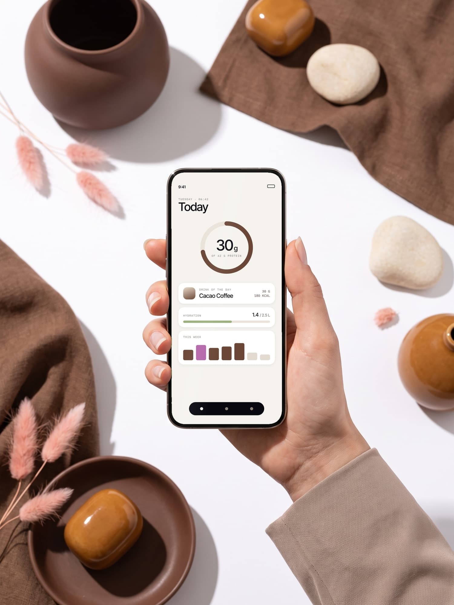 Hand holding a phone with a nutrition app: today's protein, 30 of 42 grams